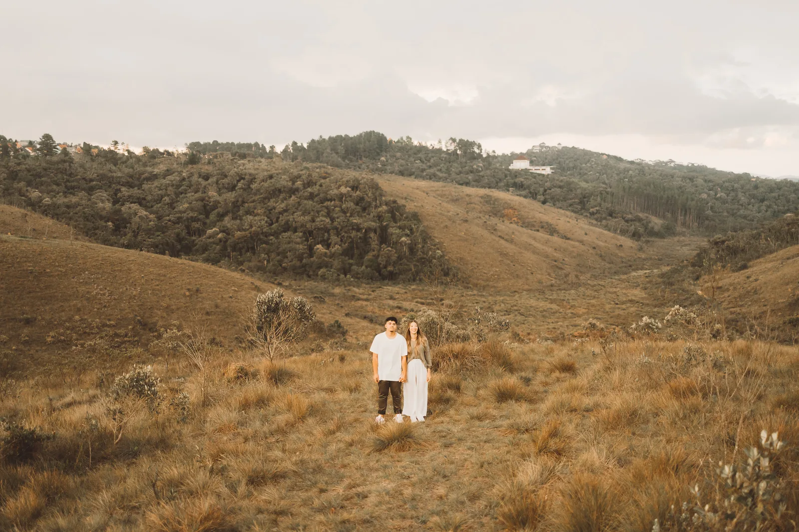 Casal pequeno na paisagem de morros e campos de Campos do Jordão