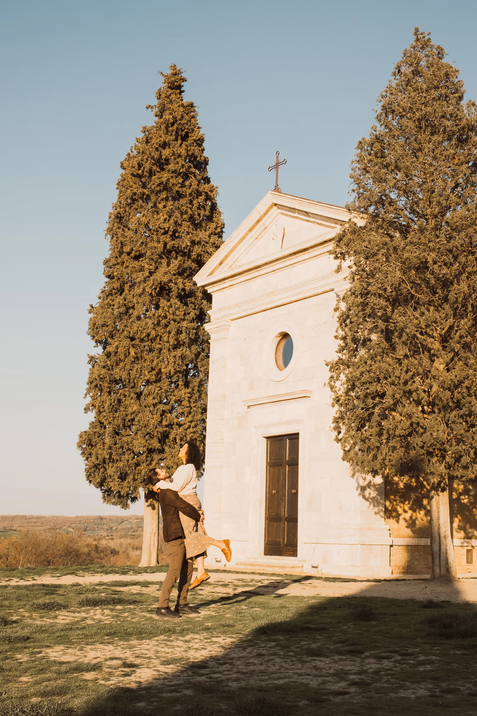 Mari e Lucas diante da capela de Vitaleta, no Val d’Orcia, Toscana